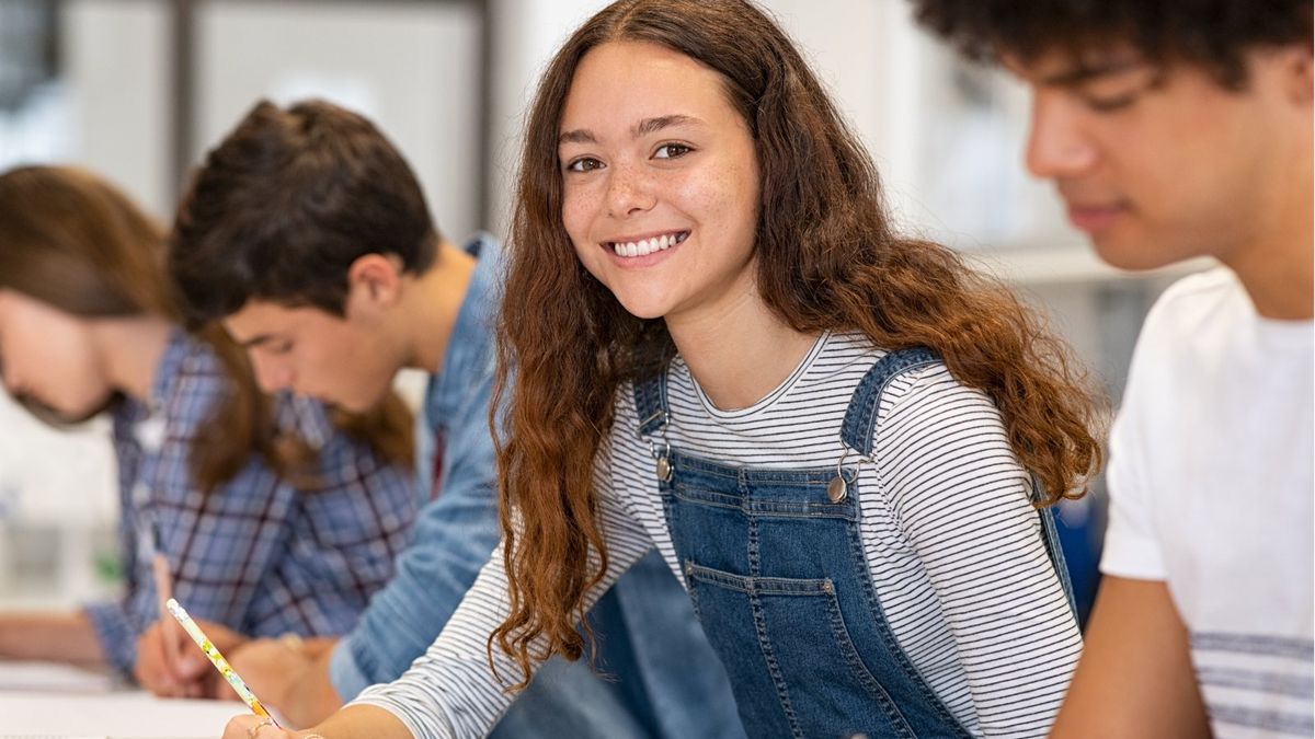 Smiling VCE student working at a desk in class