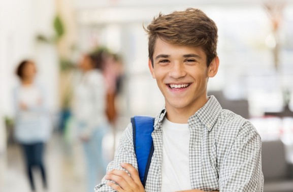 A smiling VCE student with his school bag