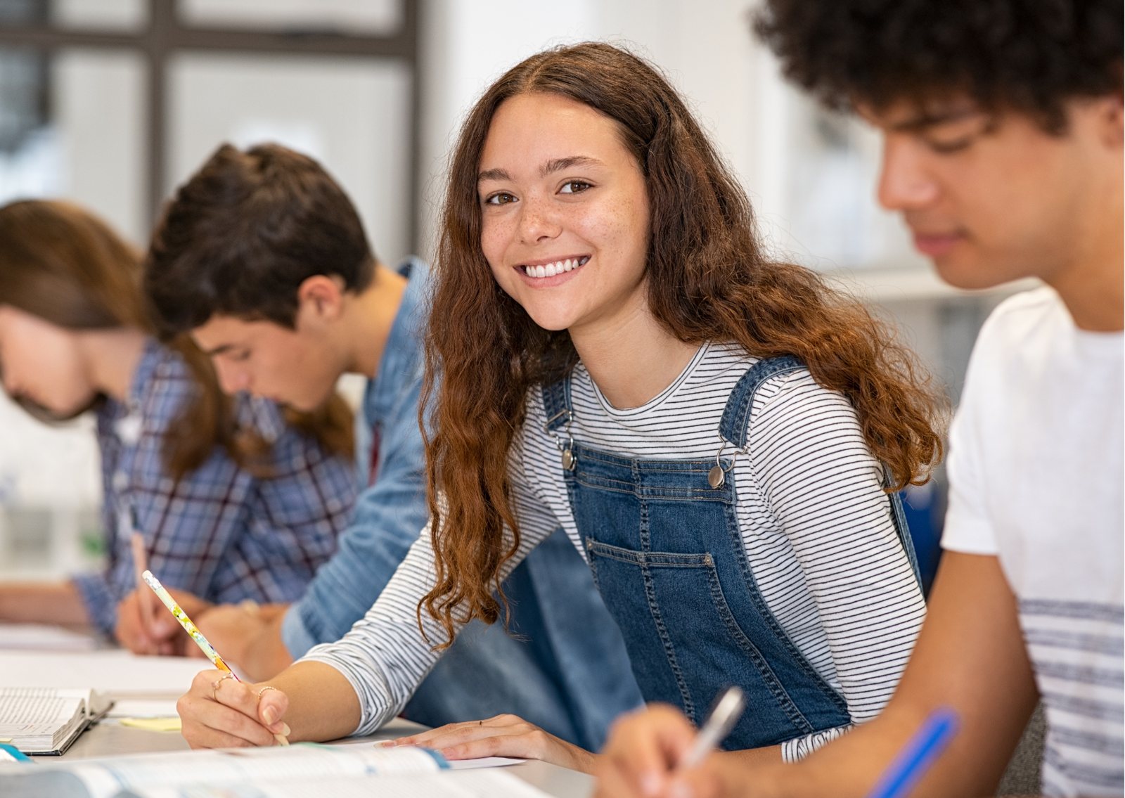 A smiling VCE student working on notes in class